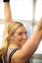 Smiling Caucasian woman working out in gymnasium