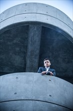 Low angle view of businessman leaning on balcony