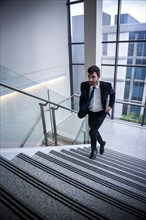 Hispanic businessman running on staircase