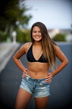 Portrait of smiling Pacific Islander girl wearing bikini in street
