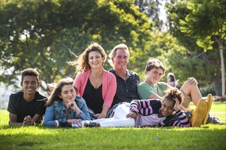 Portrait of smiling family on grass in park