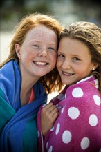 Portrait of smiling sisters wrapped in towels