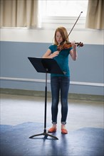 Caucasian girl practicing violin