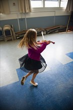 Caucasian girl practicing violin and dancing