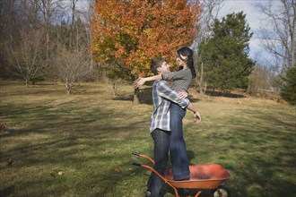 Caucasian man hugging girlfriend in yard
