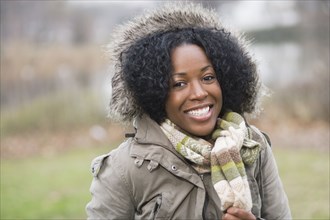 Smiling mixed race woman in fur-hooded coat
