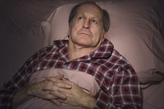 Senior Caucasian man having trouble sleeping