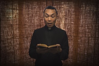 Pacific Islander priest reading bible