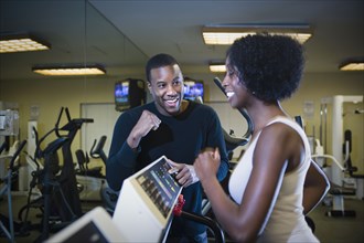 Personal trainer motivating woman on treadmill