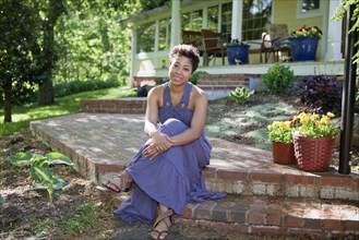Black woman sitting on step in back yard