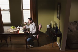 Caucasian man having dinner and reading