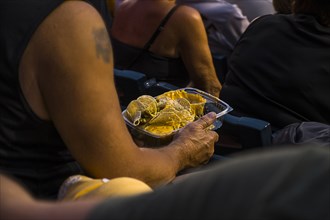Man sitting in stadium eating nachos