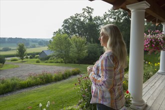 Older Caucasian woman overlooking rural scene from porch