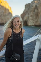 Older Caucasian woman smiling on boat
