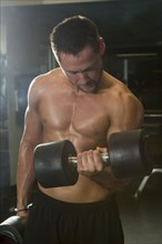 Caucasian athlete lifting weights in gymnasium
