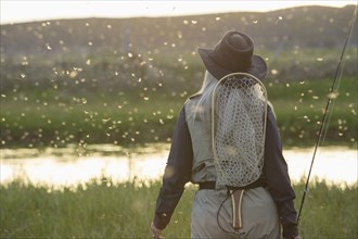 Caucasian woman wearing fishing gear in remote lake