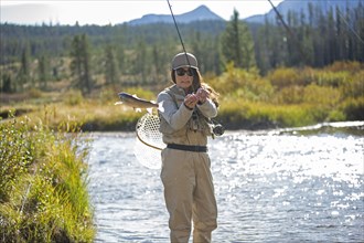 Caucasian woman fishing in rural river
