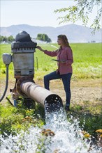 Caucasian farmer checking water pump