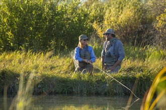 Caucasian couple fishing in river