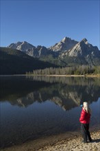 Caucasian woman admiring mountain and lake