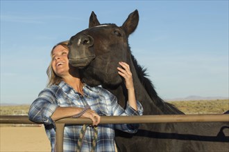 Caucasian rancher smiling with horse