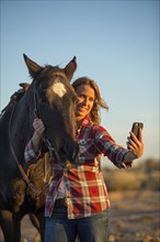 Caucasian woman taking selfie with horse