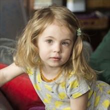 Caucasian preschooler girl sitting on sofa
