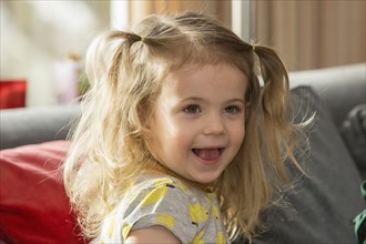 Caucasian preschooler girl smiling on sofa