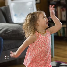 Caucasian preschooler girl playing with bubbles