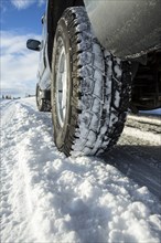 Close up of car tires driving in snow