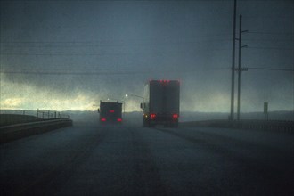 Trucks driving on stormy rural road