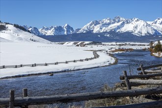 Snowy mountains and river in rural landscape