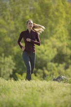 Caucasian woman running on hill