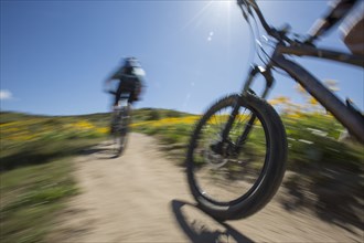 Blurred view of men riding mountain bikes