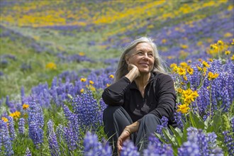 Caucasian woman smiling on hillside with wildflowers