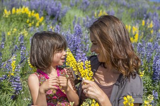 Caucasian mother and daughter holding bouquet of wildflowers