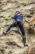 Caucasian woman climbing rock