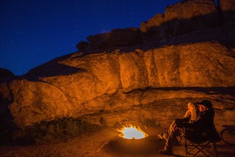 Caucasian couple near campfire at night
