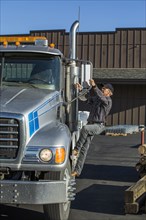Caucasian man climbing into semi-truck