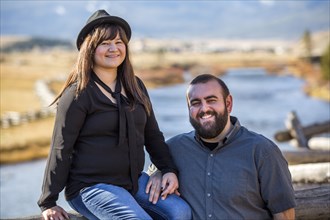 Smiling Caucasian couple posing near river