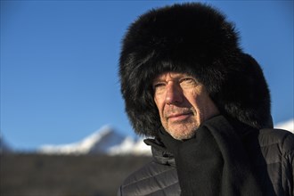 Caucasian man wearing scarf and fur hat in winter