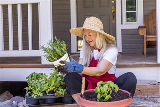Caucasian woman planting seedling on front stoop