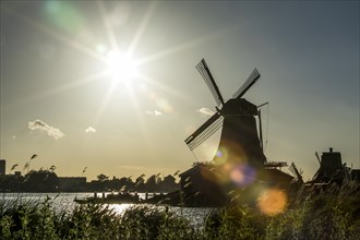 Silhouette of windmill at waterfront
