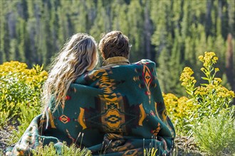 Caucasian couple wrapped in blanket admiring scenic view of landscape