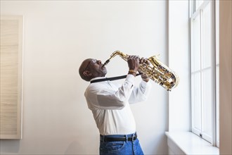 Man playing saxophone window