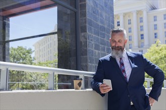 Caucasian businessman texting on cell phone outdoors