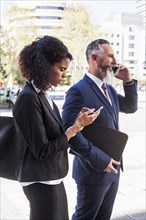 Business people using cell phones outdoors