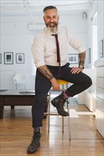 Portrait of smiling Caucasian businessman with tattoos