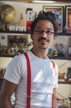Serious mixed race man wearing suspenders
