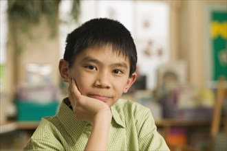 Asian boy with head in hands